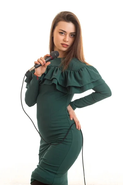 Χαριτωμένο γυναίκα σε πράσινο χρώμα φόρεμα με μικρόφωνο — Φωτογραφία Αρχείου
