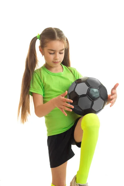 Niña rubia en uniforme deportivo jugando con pelota de fútbol — Foto de Stock