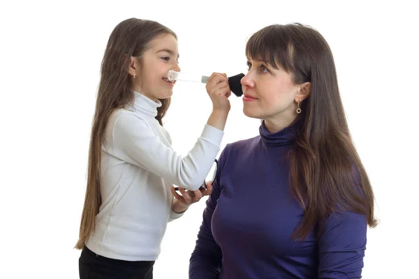 Liten flicka gör en makeup till sin mor — Stockfoto