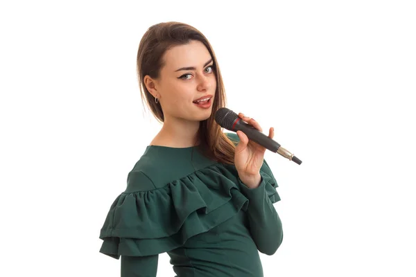 Retrato de una hermosa joven que canta en un micrófono — Foto de Stock
