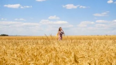 güneşli bir güzel kız buğday alanına gider