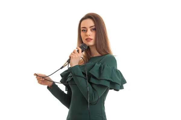 Симпатична брюнетка в зеленій сукні з мікрофоном — стокове фото