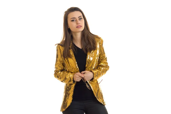 Очаровательная элегантная женщина в золотой куртке смотрит в камеру — стоковое фото