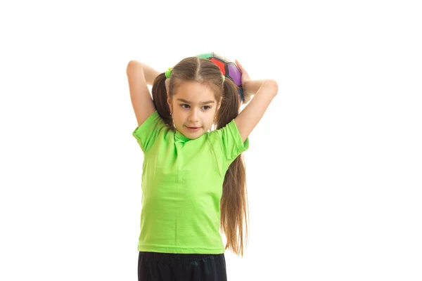 Menina bonito em camisa verde com bola nas mãos — Fotografia de Stock