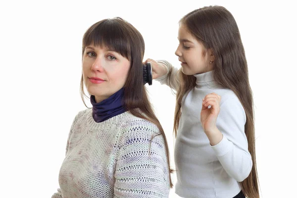 Маленькая девочка расчесывает волосы своей матери — стоковое фото