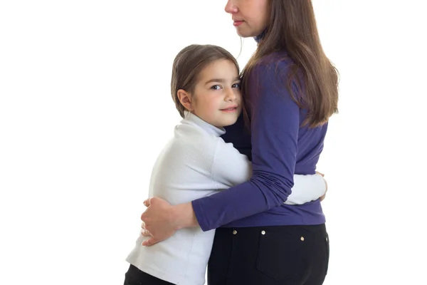 Маленькая девочка обнимает свою мать в студии — стоковое фото