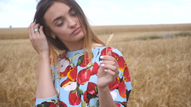 buğday spikelet ve katlanmış yakın tutan genç kadın