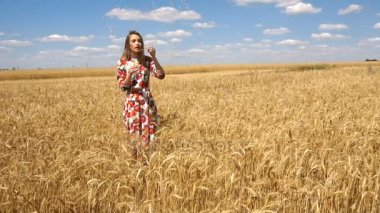 genç bayan bir buğday ayakta mavi gökyüzü karşı alan ve sabun-kabarcık ağır çekimde açılırsa