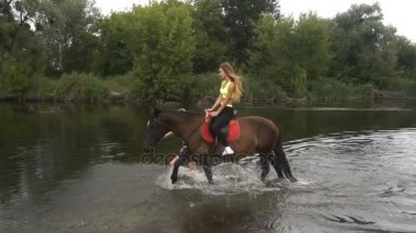 çekici kız bir atın üzerinde oturanbir ve rides göl üzerinde