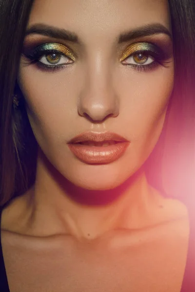 Primer plano de la mujer de belleza con multicolor maquillaje mirando a la cámara — Foto de Stock