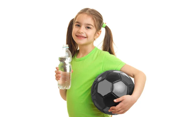Μικρό κορίτσι με τη μπάλα στα χέρια πίνει νερό — Φωτογραφία Αρχείου