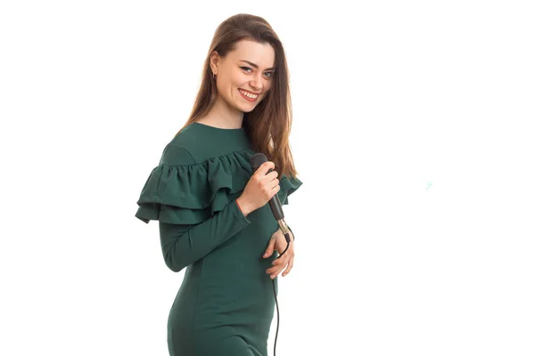 Χαρούμενη κοπέλα με το μικρόφωνο στα χέρια στο πράσινο φόρεμα — Φωτογραφία Αρχείου