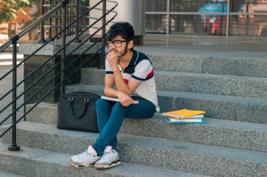 Merdivende oturup kitap ile güzel düşünceli öğrenci