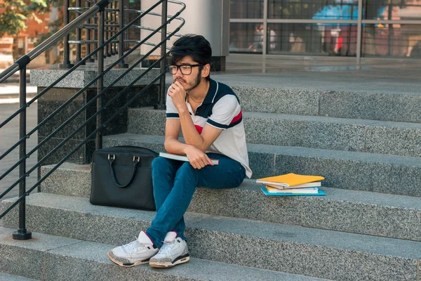 Merdivende oturup kitap ile güzel düşünceli öğrenci