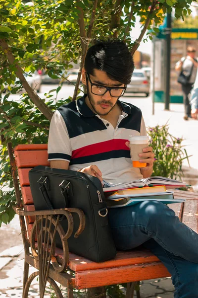 Dikey gözlüklü bir kitap ve bir fincan kahve ile göz alıcı adam portresi