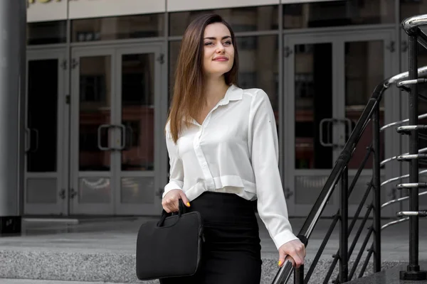 Una giovane ragazza affascinante in una camicia bianca da lavoro sorridente — Foto Stock