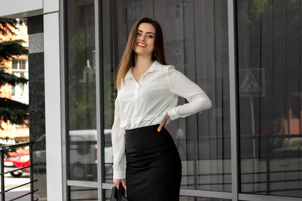 Gelukkig zakenvrouw in zwart-wit uniform glimlacht in openlucht — Stockfoto