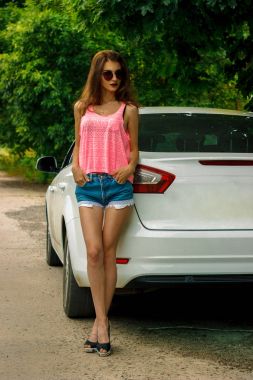 hotpants ve pembe bir t-shirt ayakta car yakınındaki güzel Bayan