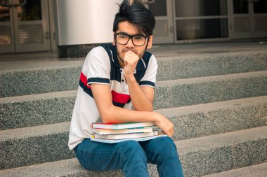 oturma düşünce ile kitap okumak için gözlüklü genç sevimli adam