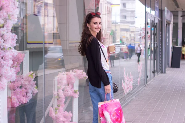 Dulce encantadora dama cerca de tiendas urbanas vale la pena con paquetes — Foto de Stock