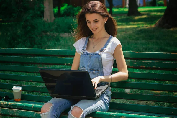 美丽的女人坐在板凳上的笔记本电脑 — 图库照片