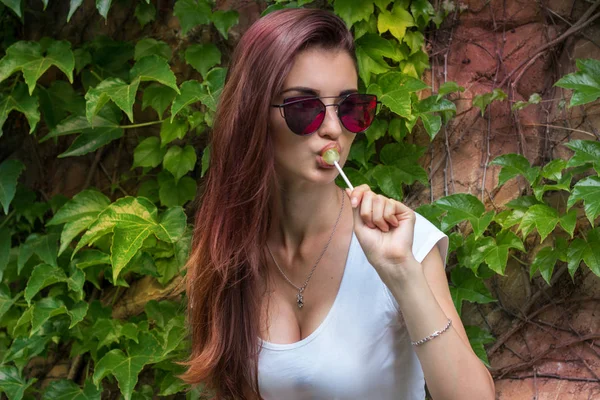 lolipop ağız ve gözlük ile genç seksi esmer