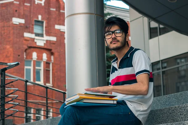 Ładny zamyślony facet w okularach trzyma książkę — Zdjęcie stockowe