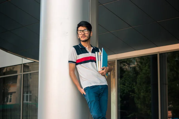 Schattige jonge student jongen in glazen met boeken in handen — Stockfoto