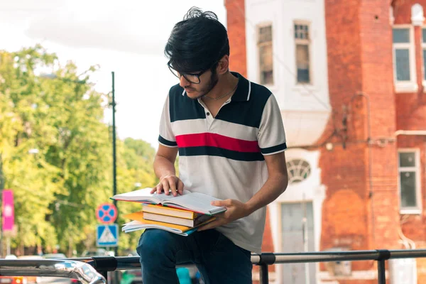 brunette student guy reading a book