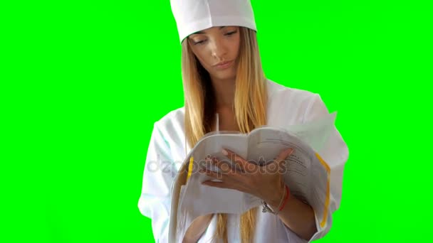 Jonge blonde verpleegkundige duimen een nobebook in uniform — Stockvideo