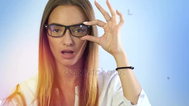 Милая молодая блондинка проверяет зрение виртуальными буквами в воздухе. — стоковое видео