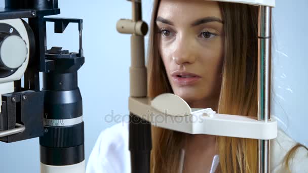 Paciente joven mirando a la máquina de prueba ocular en oftalmólogo — Vídeos de Stock