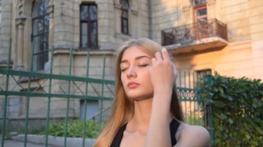 Güneş altında bir sokakta genç güzel sarışın standları