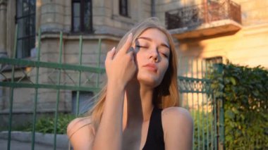 büyüleyici bir genç sarışın ayakta gözleri ile sokakta kapalı