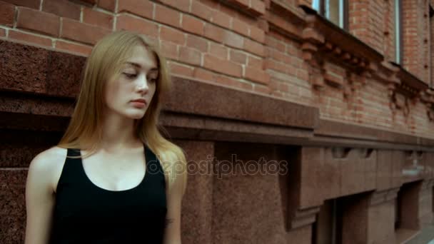 Beautiful blonde standing on the street and the ball straightens hair — Stock Video