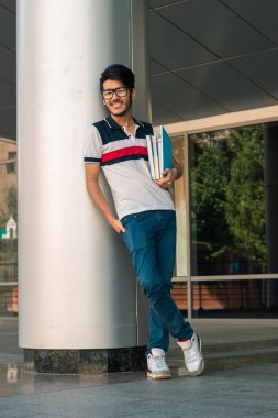 sokakta duran neşeli genç adam kameraya benziyor