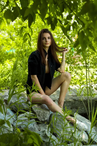 Delgado sexy menina sentado no rochas — Fotografia de Stock