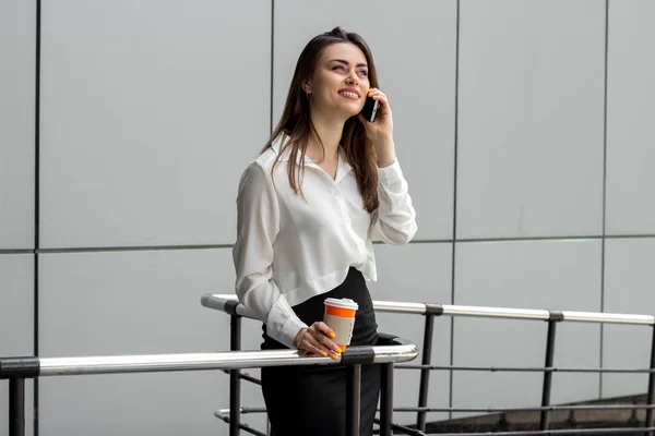 Happy business woman standing and talking on the phone — Stock Photo, Image