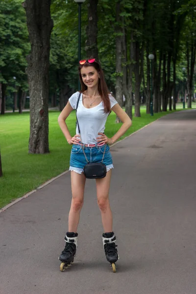 Flaco suerte chica cabalgando en el parque, patinaje — Foto de Stock