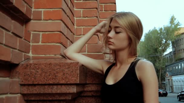 Wonderful blonde stands on the street and leads the hand through hair — Stock Video