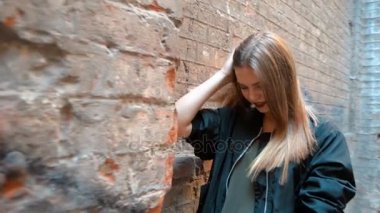 çekici sarışın kamerada poz bir sokakta duruyor ve saç el düzeltiyor