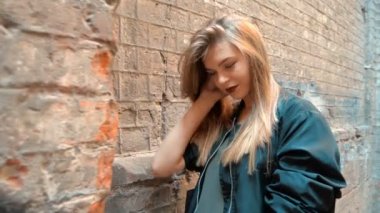 sarışın gülümseyen çarpıcı kameraya bakar ve saç düzeltiyor