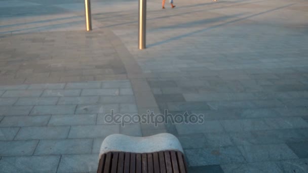 Красивая девушка с длинными волосами лежит на скамейке — стоковое видео