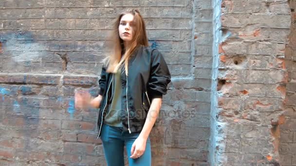 Attractive young blonde stands near a wall in the street — Stock Video