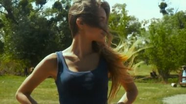 Kız bir alan ve saç ayakta rüzgara karşı hareket