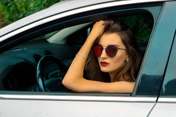 Porträt eines schicken Mädchens mit Brille im Auto — Stockfoto