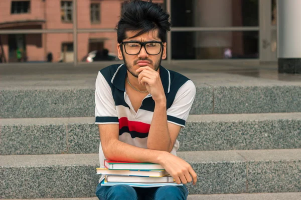 Poważne, młody student w okularach siedzi na schodach — Zdjęcie stockowe