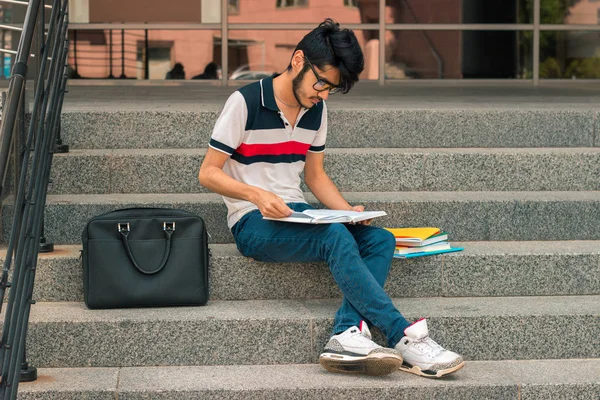 yakışıklı olan cadde ve okuma kitapları oturan