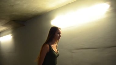 uzun saçlı güzel kadın tarafından duvarlar ışıklar ile karanlık sokakta yürüyor