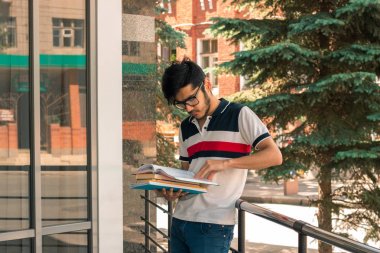 Gözlüklü şirin genç öğrenci caddenin ortasında duruyor